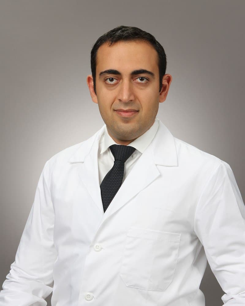 Dr. Farbod Youshei, DMD, in his white coat at the Allure Dental Arts office